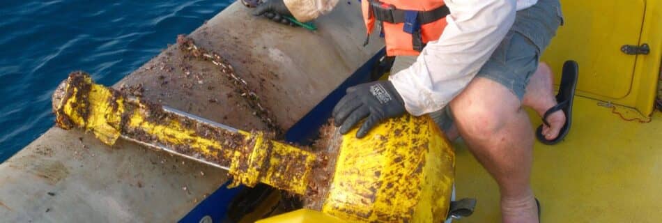 A field technician on a boat retrieving Obscape offshore monitoring instruments from the sea